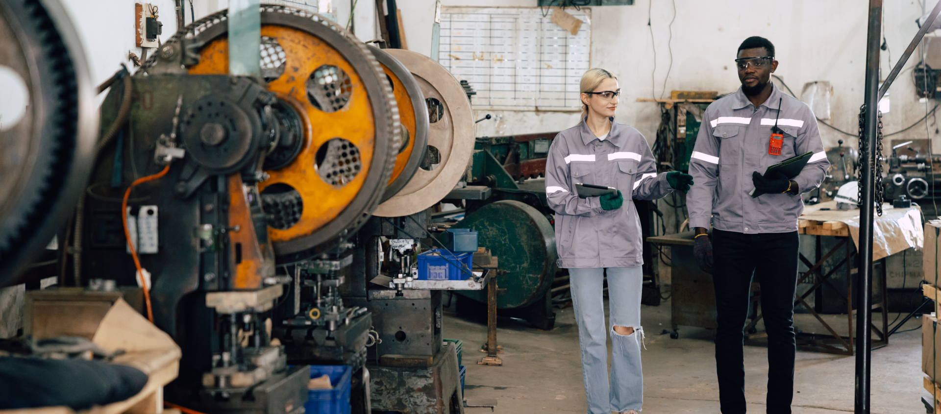 Two people working in auto shop talking