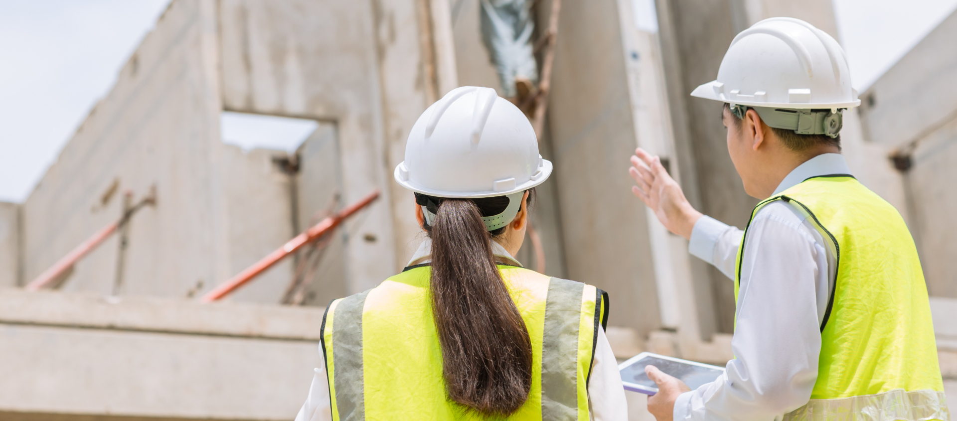 Construction workers looking at building frame
