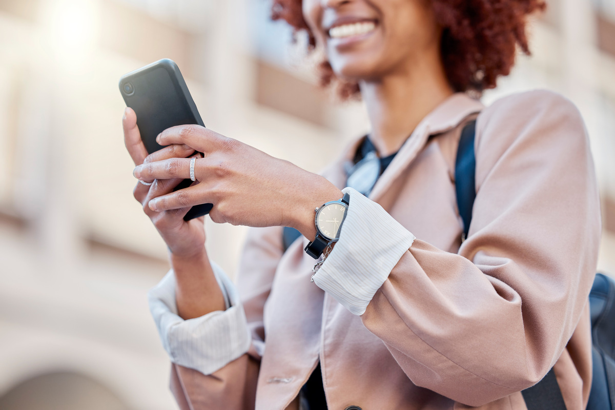 woman smiling while texting on phone