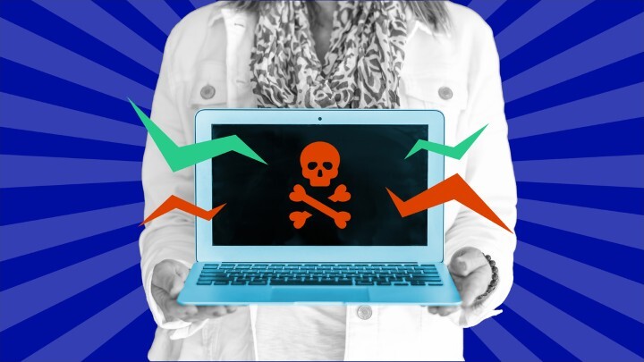 woman holding a computer that has graphic of skull on screen